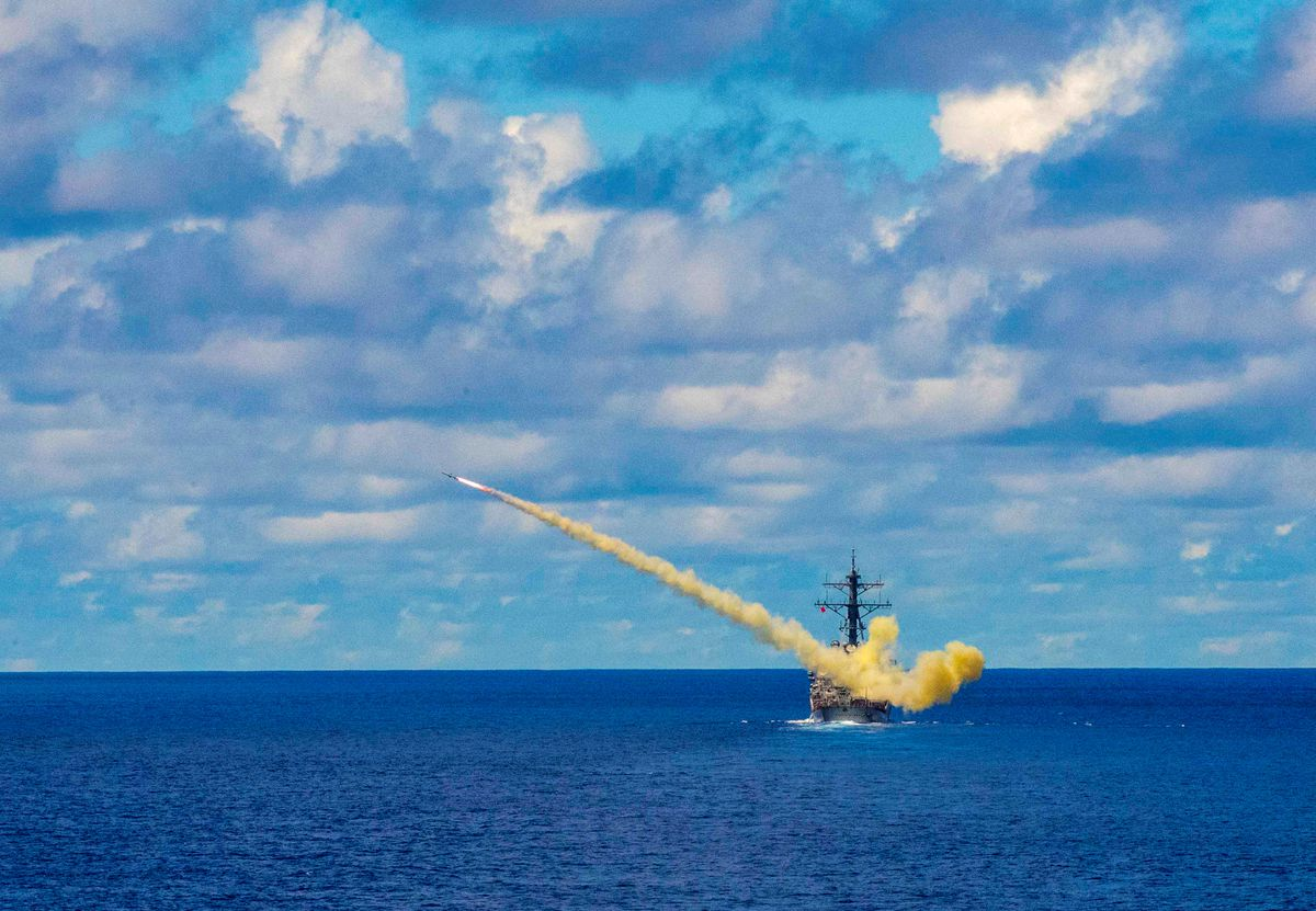 A missile being launched from a warship at sea.