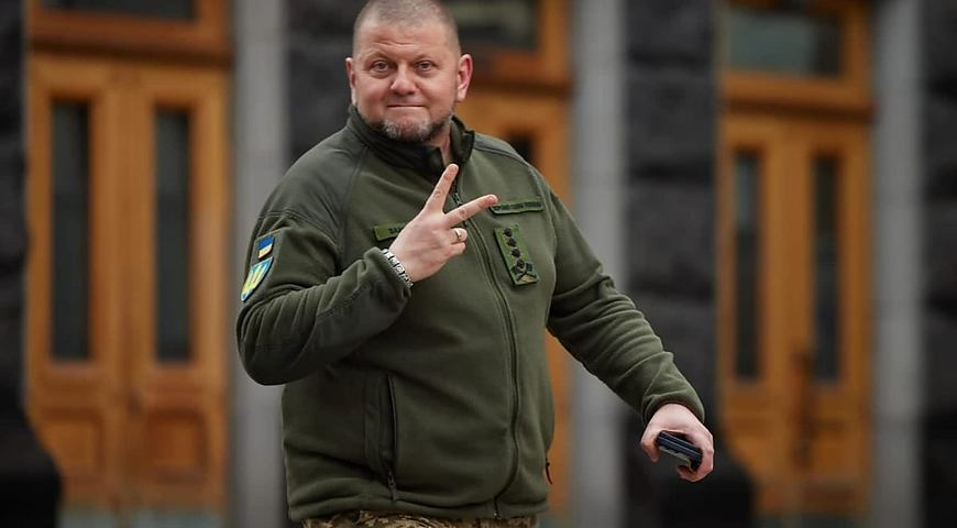 A man in military clothing making a V sign.
